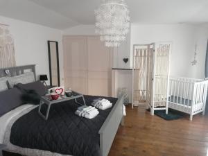 a bedroom with a bed and a chandelier at Romance en Baie de Somme in Saint-Valery-sur-Somme
