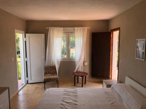 a bedroom with a bed and a chair and windows at Villa tosalet in Jávea +2 photos
