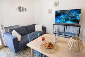 salon z kanapą i stołem w obiekcie siciliacasevacanze - Marina Domus 82 w mieście Marina di Ragusa