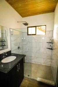 a bathroom with a sink and a glass shower at Teva Hotel & Jungle Reserve in Manuel Antonio