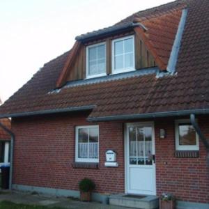 a red brick house with a white door at Ferienwohnung-Kapitaens-Kajuete in Wankendorf