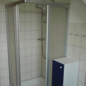a bathroom with a shower with a blue cabinet in it at Ferienwohnung-Kapitaens-Kajuete in Wankendorf