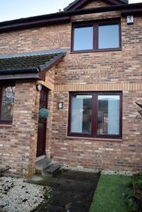 a brick house with two windows and a door at Kelpies Serviced Apartments Hamilton- 2 Bedrooms in Falkirk