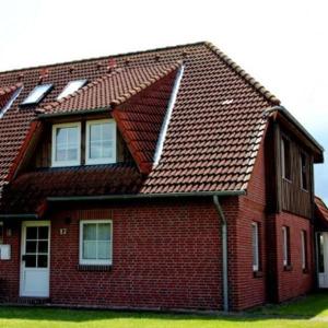 a red brick house with a brown roof at Ferienwohnung-Wiesengrund in Petersdorf auf Fehmarn
