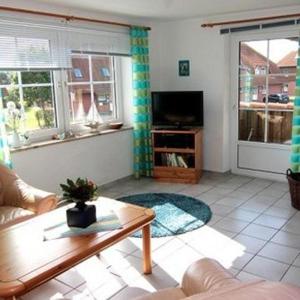 a living room with a couch and a tv at Ferienwohnung-Wiesengrund in Petersdorf auf Fehmarn