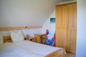 a bedroom with a bed and a blue chair at Ferienwohnung-Elke in Lemkenhafen auf Fehmarn