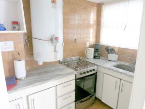 a kitchen with a stove and a sink at Cabo Corrientes Center in Mar del Plata