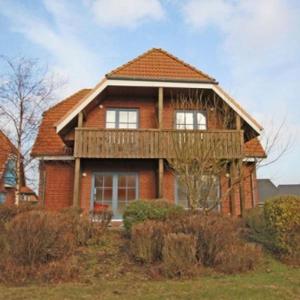 a large brick house with a deck on top of it at Morgenroete in Lemkenhafen auf Fehmarn