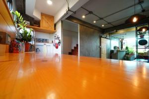a large wooden table in an empty room at Jellyfish Hostel in Jomtien Beach