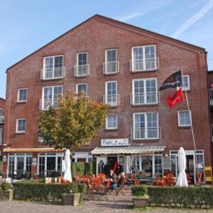 a large brick building with people sitting outside of it at Ferienwohnung-Hafenmeisterei in Orth