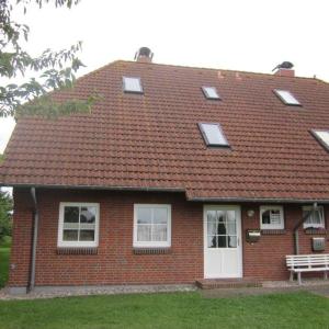 a red brick house with a roof with windows at Ferienwohnung-Achtern-Diek in Petersdorf auf Fehmarn