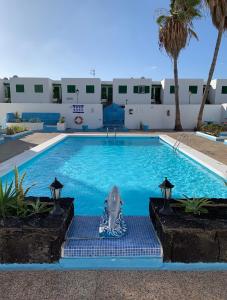 a dolphin statue sitting in the middle of a swimming pool at Puerto del Carmen Luxury Apartment in Tías