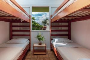 two beds in a room with a window at Vila do Mar in Florianópolis