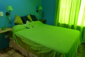 a green bed in a room with a window at Cabañas Teoba in San José +32 photos