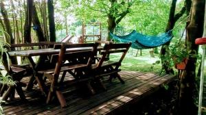 a wooden deck with a picnic table and a hammock at Cabañas Teoba in San José