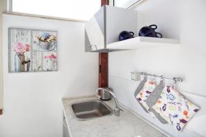 un pequeño baño blanco con lavabo y lavabo en siciliacasevacanze - Marina Domus 82, en Marina di Ragusa