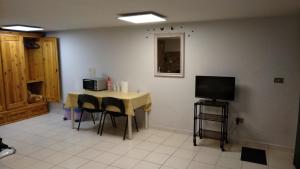 ペスカーラにあるMonolocale Via Leopardiのテーブル、椅子、テレビが備わる客室です。