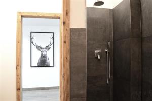 łazienka ze zdjęciem jelenia na ścianie w obiekcie Apartment El Molin - Alpe Cermis Dolomites w Calavese