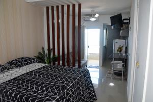 Schlafzimmer mit einem Bett mit einer schwarzen und weißen Bettdecke in der Unterkunft Bahia Flat ap. 311 in Salvador