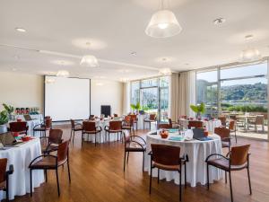 une salle de banquet avec des tables, des chaises et un écran dans l'établissement Acqua Hotel, à Mill Valley