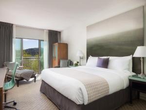 a hotel room with a large bed and a balcony at Acqua Hotel in Mill Valley