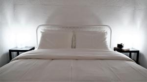 a white bed with white sheets and two night stands at 17 da Rua da Estação in São Pedro do Corval +30 photos