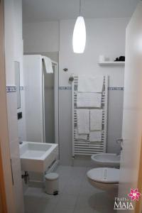 a white bathroom with a sink and a toilet at Prati di Maja B&B in Miglianico
