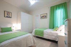a bedroom with two beds and a green curtain at La Entallada in Las Playas