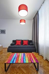 uma sala de estar com um sofá e um tapete colorido em Stadthalle - FamilyCityApartment em Viena