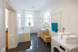 baño blanco con lavadora y lavamanos en Stadthalle - FamilyCityApartment, en Viena