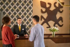 a man in a suit and a woman standing at a counter at Valle Del Este Golf Resort in Vera