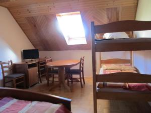 Zimmer mit einem Tisch, einem Schreibtisch und Etagenbetten in der Unterkunft Tourist Farm Ljubica in Poljane nad Škofjo Loko