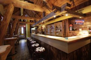 a bar in a restaurant with wooden walls and stools at Hotel Tia Monte in Kaunertal