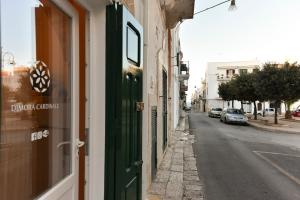 una puerta verde en un edificio en una calle en Dimora Cardinale, en Polignano a Mare