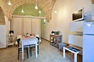 a dining room with a table and a tv on a wall at Dimora Cardinale in Polignano a Mare