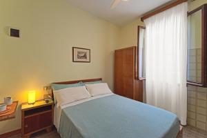a bedroom with a bed and a desk and a window at Albergo Al Gobbo in Venice