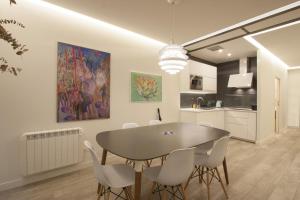 eine Küche und ein Esszimmer mit einem Tisch und Stühlen in der Unterkunft Ku by Oldtown San Sebastian apartments in San Sebastián