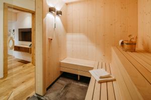 uma sauna com um banco numa sala de madeira em Fernsicht Alpen-Apartments em Lech am Arlberg