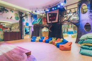 a childrens play room with a tree and colorful couches at Iberostar Selection Paraíso Maya - All Inclusive in Puerto Morelos