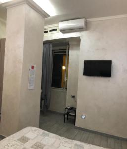 um quarto com uma televisão na parede em Dante Street 49 em Nápoles