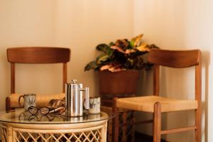 einen Tisch mit Brille und zwei Stühlen und eine Pflanze in der Unterkunft The Downtown Clifton Hotel in Tucson