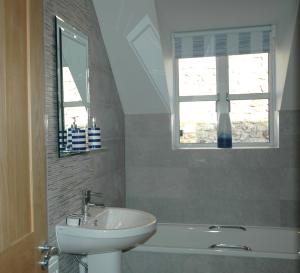 a bathroom with a sink and a bath tub and a window at The Starting Gate, Bruton in Bruton
