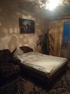 1 cama en un dormitorio con una pintura en la pared en Apartment on Gagarina 2, en Zlatoust