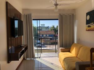 Una sala de estar con un sofá y una ventana grande. en Residencial De Aluguel, en Bombinhas