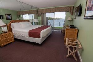 een slaapkamer met een bed en uitzicht op het water bij Palm Beach Resort in Lake Worth