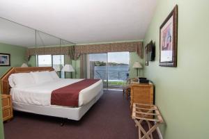 een slaapkamer met een bed en een groot raam bij Palm Beach Resort in Lake Worth