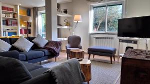 a living room with a couch and a tv at Lisbon Coast Family Home in São Domingos de Rana