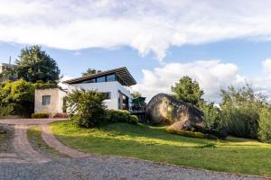 a house on a hill with a large rock at Farallones de Sutatausa El Rincón in Sutatausa