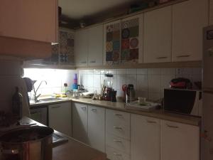 a kitchen with white cabinets and a counter top at Playa Miramar in Viña del Mar +2 photos