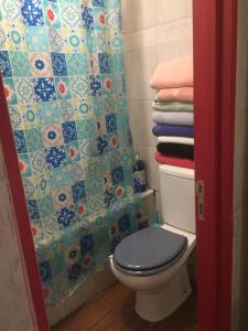 a bathroom with a toilet with a shower curtain and towels at Playa Miramar in Viña del Mar